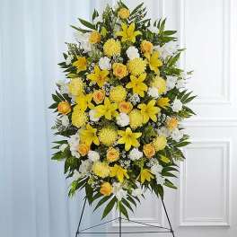Standing floral spray with yellow lilies, roses, and white flowers