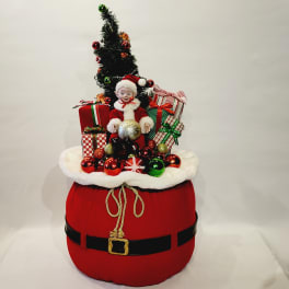 Santa figurine with Christmas tree, ornaments, and wrapped gifts on a red base