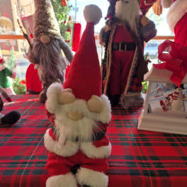 Santa figurine on a red plaid tablecloth with other holiday decorations
