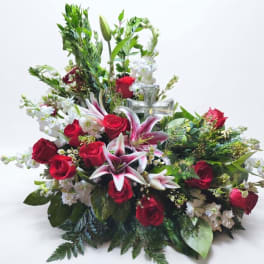 Red roses and pink lilies in a large white floral arrangement