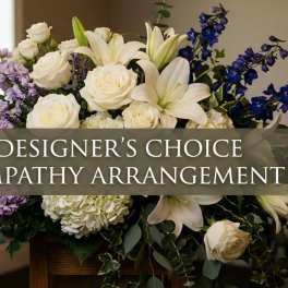White lilies and roses with purple flowers in a sympathy arrangement