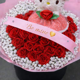 Hello Kitty plush in a bouquet of red roses and white baby's breath