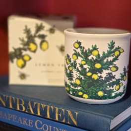 White ceramic mug with a green-and-yellow botanical pattern