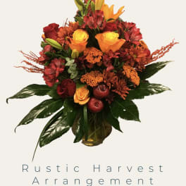 Rustic bouquet of red, orange, and yellow flowers in a vase