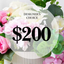 Pink and white roses with greenery behind a $200 designer's choice label