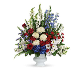 Mixed red, white, and blue flowers arranged in a white vase