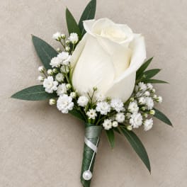 White rose boutonniere with baby's breath and green leaves