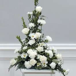 Tall white floral arrangement with roses and daisies on a stand