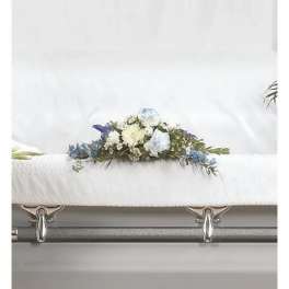 White casket with a blue and white floral spray on top