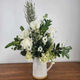 White floral arrangement in a ceramic pitcher vase