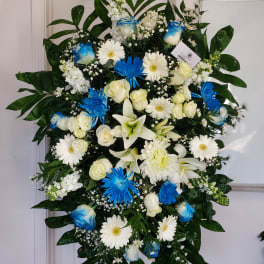 Large standing floral spray with white and blue flowers on an easel