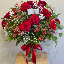 Bouquet of red roses with white baby's breath in a glass vase