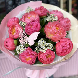 Pink peony bouquet wrapped in pale pink paper with a butterfly decoration
