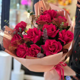 Bouquet of bright pink roses wrapped in blush paper