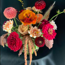 Mixed bouquet with dahlias, roses, and bright orange ranunculus