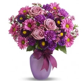 Pink and purple bouquet in a lavender vase with a ribbon