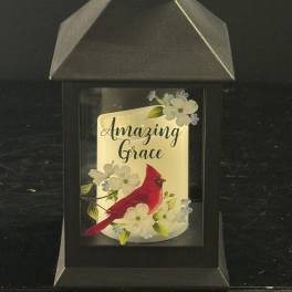 Black lantern with a cardinal and floral design reading "Amazing Grace"