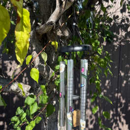 Hanging metal wind chime on a tree branch