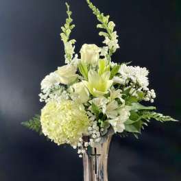 White floral arrangement in a tall silver vase