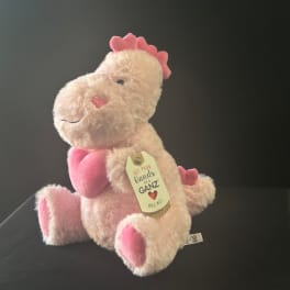Pink plush dinosaur with a heart on its chest and a hanging tag