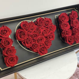 Red roses arranged in a black box to spell "I ♥ U"