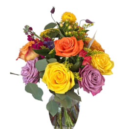 Colorful bouquet of roses and mixed flowers in a glass vase