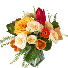 Mixed bouquet of roses, tulips, and a gerbera daisy in a glass vase