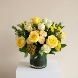 Yellow and white rose arrangement in a glass vase