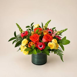 Mixed bouquet of red and yellow roses in a dark green vase