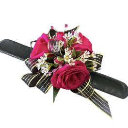 Pink rose corsage with white filler flowers on a black wristlet