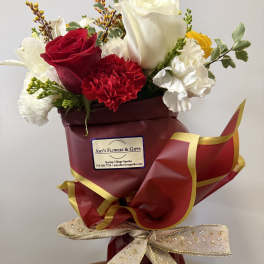 Bouquet of red and white roses with carnations wrapped in burgundy paper