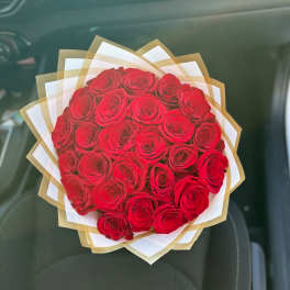 Bouquet of red roses wrapped in white and gold paper