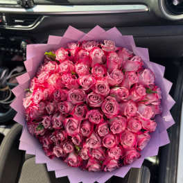 Large bouquet of pink roses wrapped in lavender paper