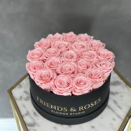 Pink roses arranged in a round black box