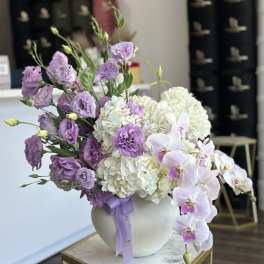 Lavender flowers and white hydrangeas in a round white vase