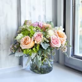 Bouquet of pastel roses in a clear glass vase