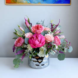 Pink and blush roses in a silver vase with eucalyptus