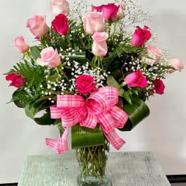 Pink and hot pink roses in a clear glass vase with a pink plaid bow