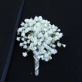 White baby's breath boutonniere on a dark suit