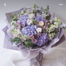 Lavender bouquet with roses and hydrangeas wrapped in lilac paper