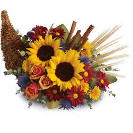 Autumn bouquet with sunflowers, roses, and daisies in a wicker cornucopia