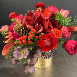 Red and pink floral arrangement in a gold container
