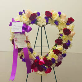Heart-shaped floral wreath on a stand with roses and chrysanthemums