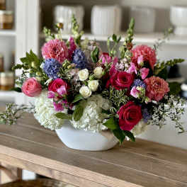 Mixed bouquet in a white bowl vase with pink, white, and purple flowers