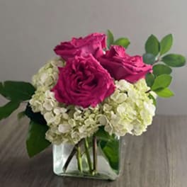 Pink roses with white hydrangeas in a clear glass vase