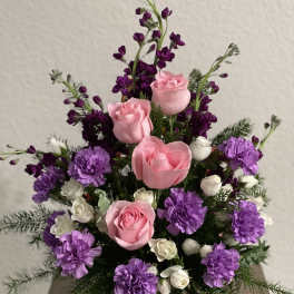 Pink roses and purple carnations in a green vase