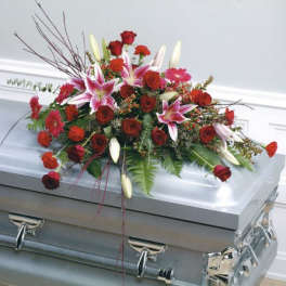 Red roses and pink lilies arranged on a silver casket