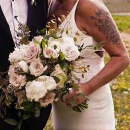 Bride holding a bouquet of pale roses and white flowers