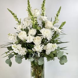 White roses and chrysanthemums in a clear glass vase