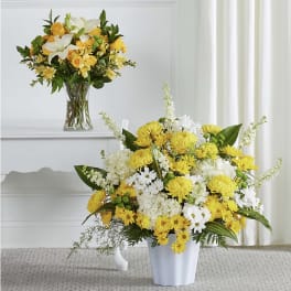 Yellow and white floral arrangements in clear and white vases